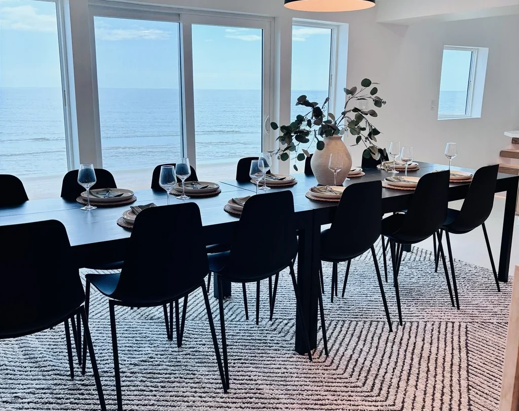 Long dining table for twelve facing the ocean windows