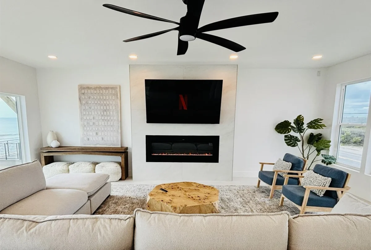 Living room with a linear fireplace and blue armchairs