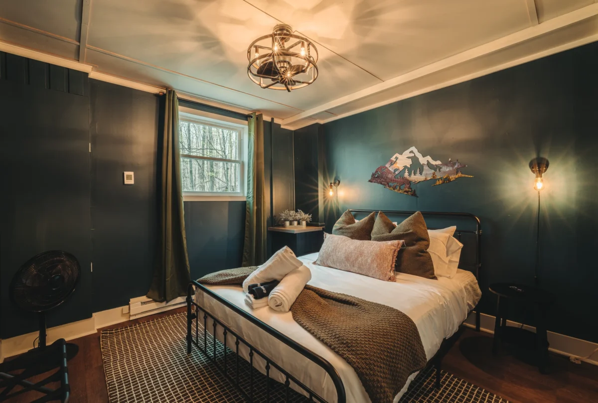 Bedroom with dark teal walls and a mountain print