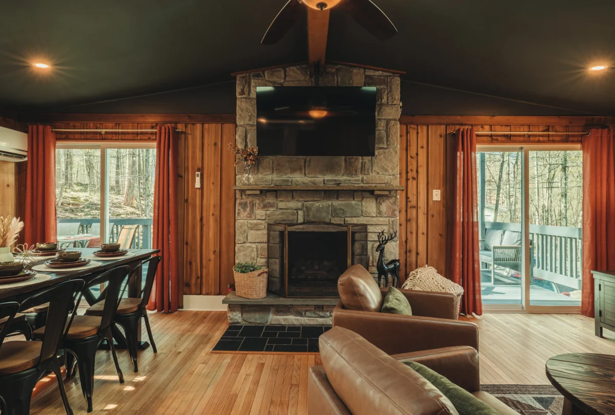 Living room with a stone fireplace under a timber ceiling