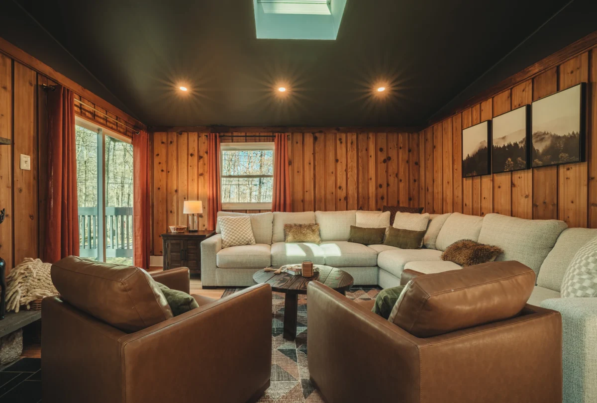 Living room with pale sectional sofas and skylights