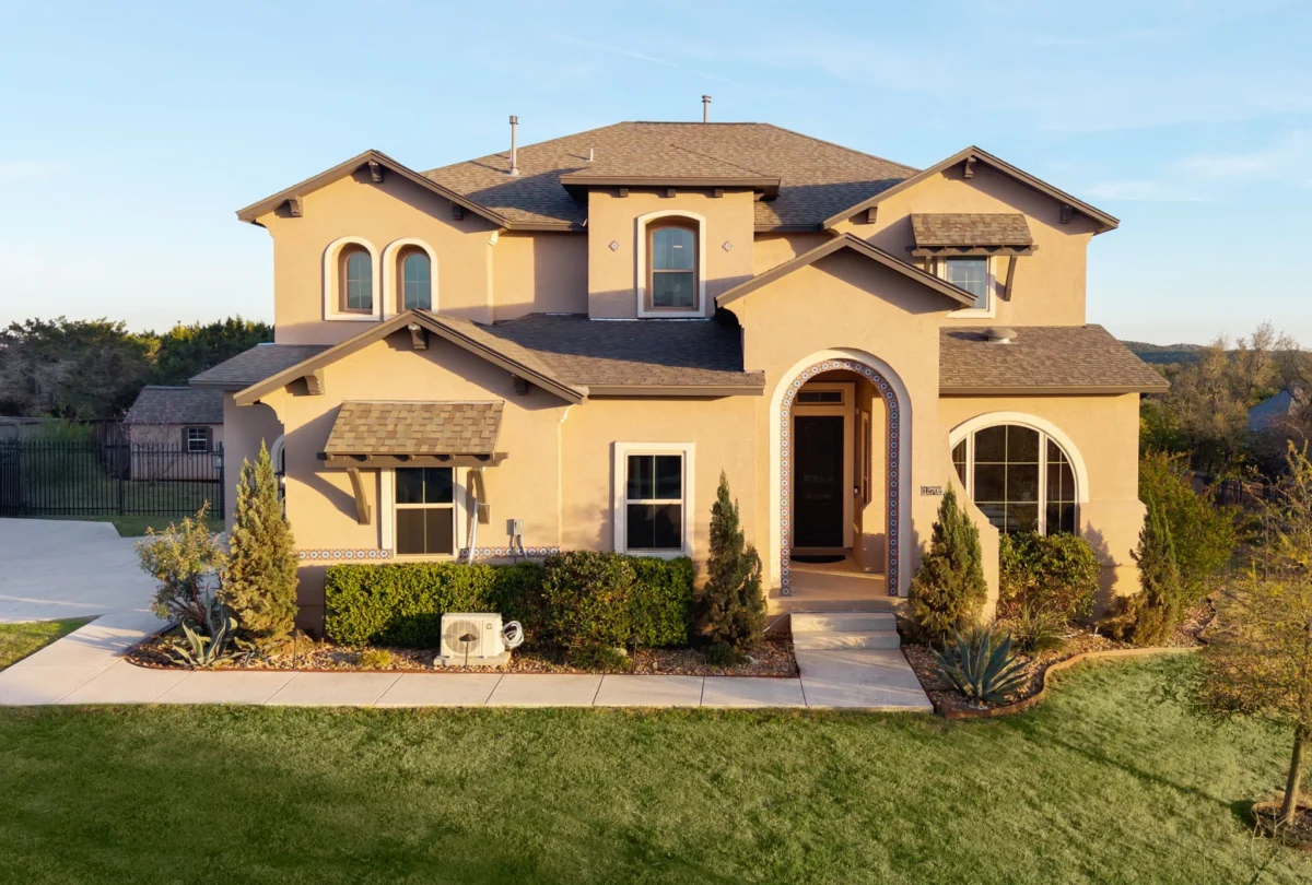 Stucco house with a tile roof seen from the front lawn