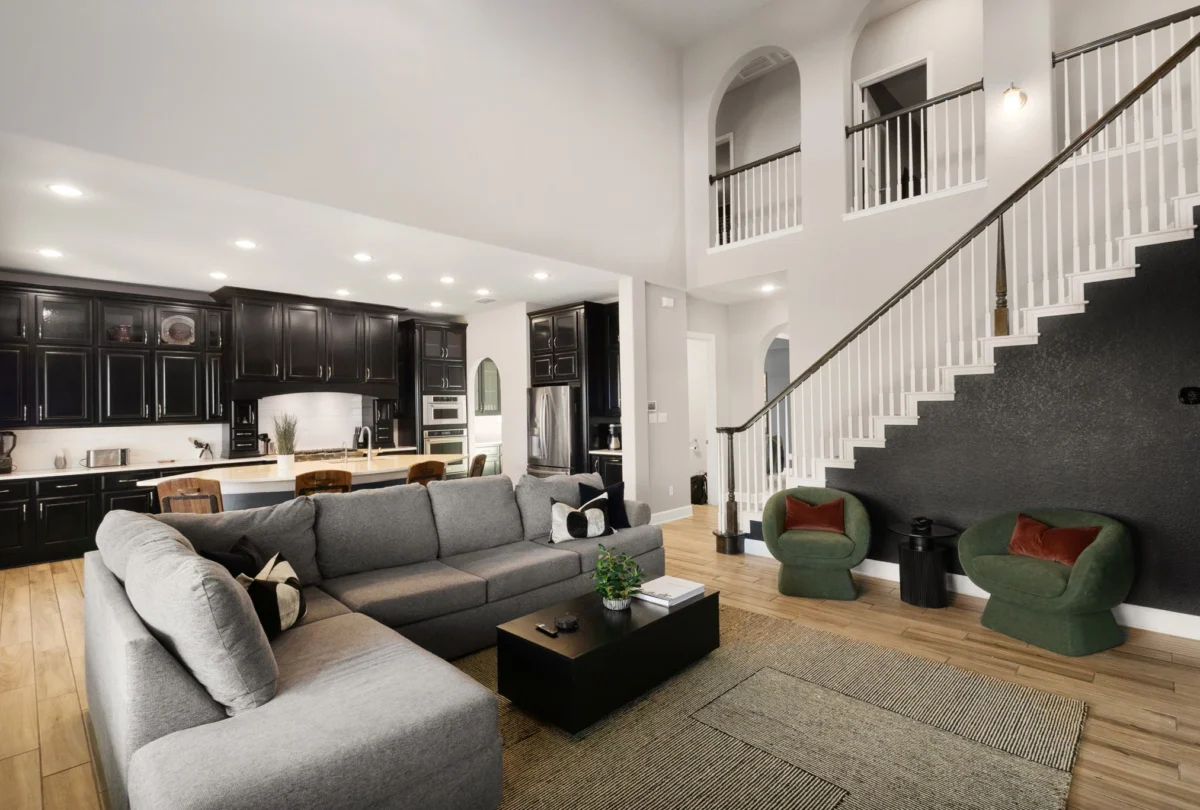 Double-height living room with grey sofas and a staircase