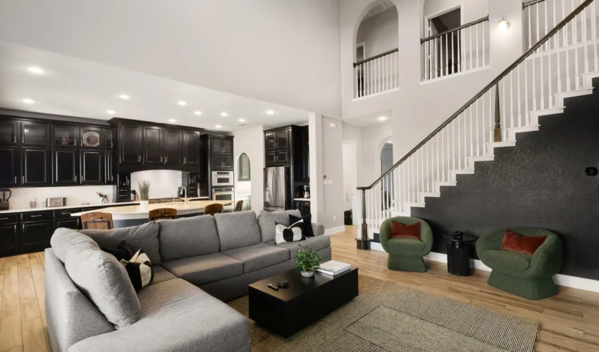 Double-height living room with grey sofas and a staircase