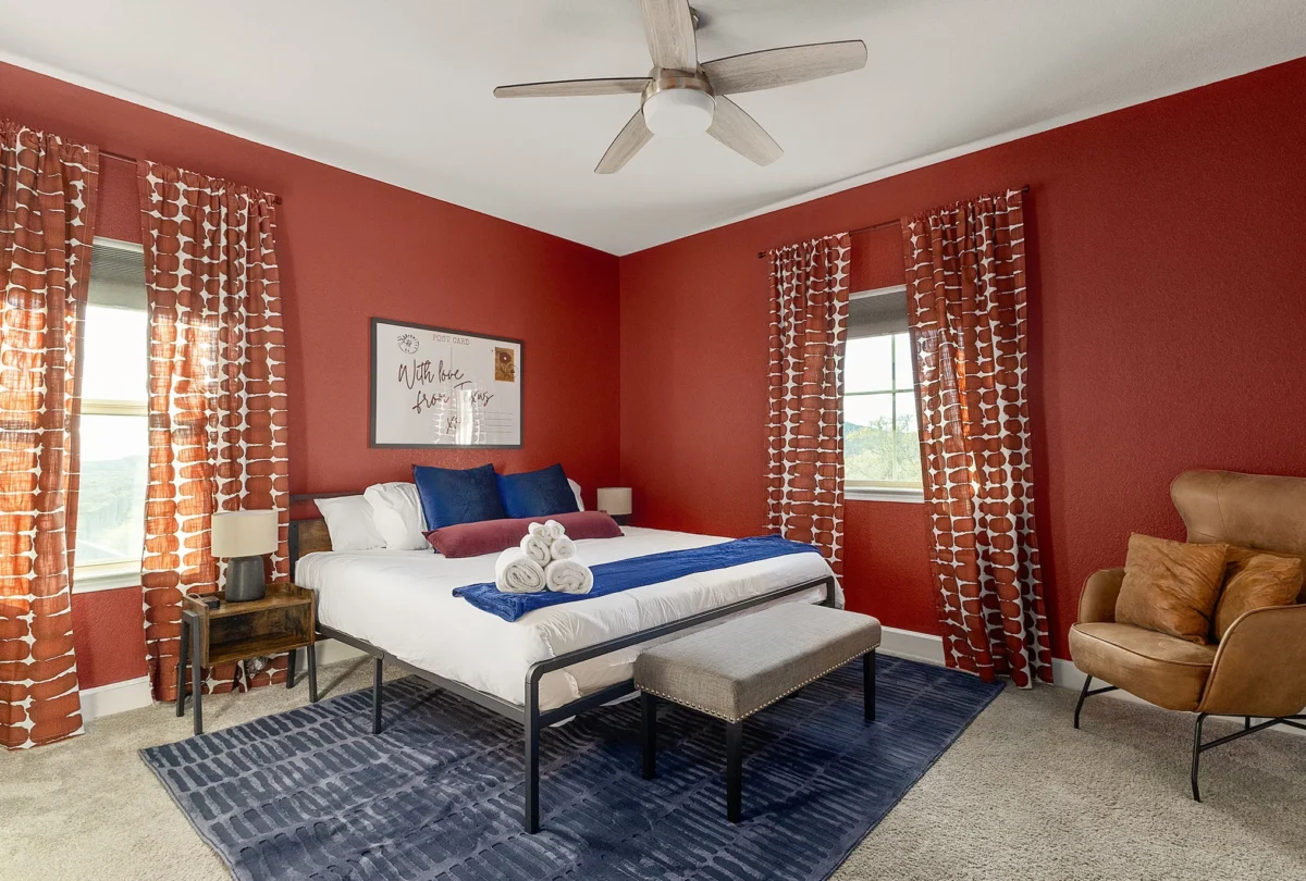 Bedroom with a deep red wall and patterned curtains