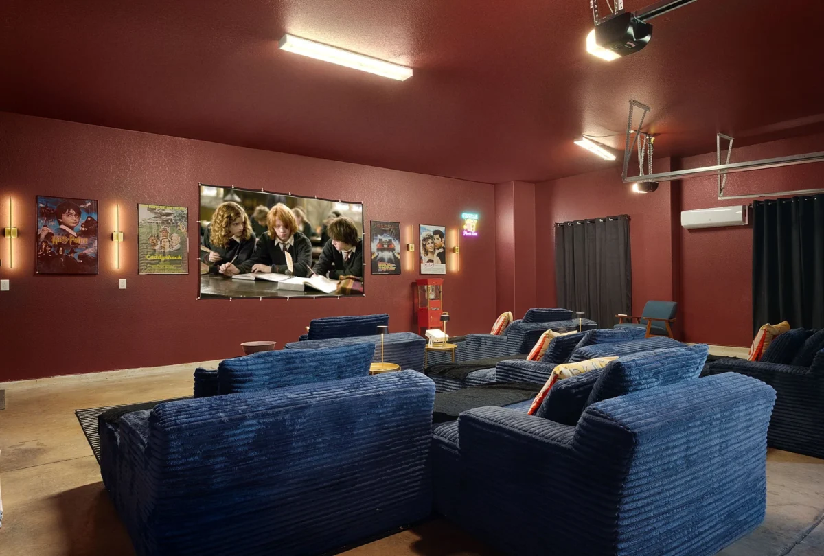Home cinema in the garage, with blue sofas and a deep red wall