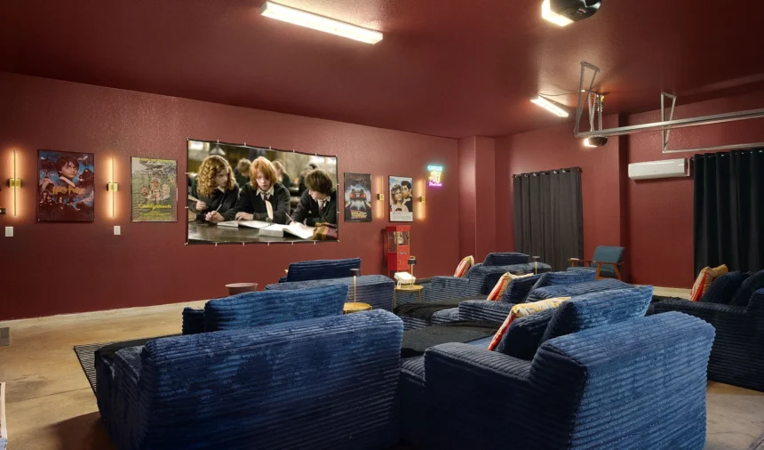 Home cinema in the garage, with blue sofas and a deep red wall