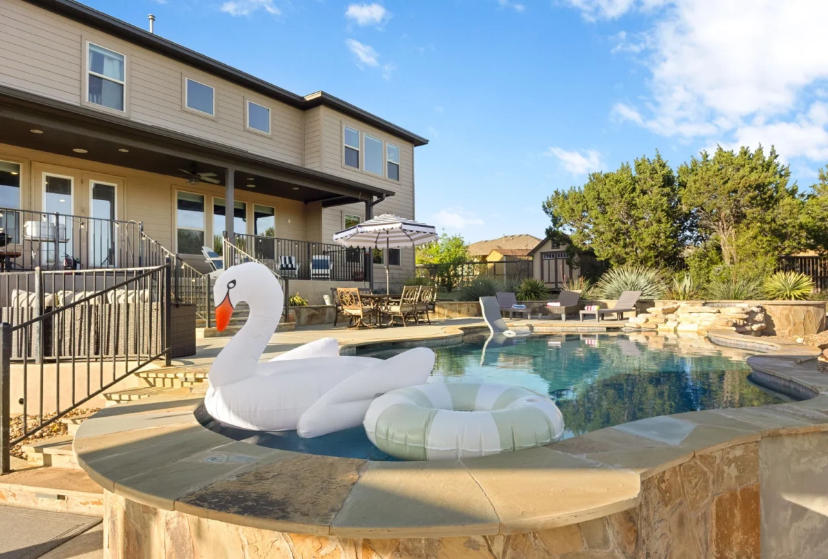 Swimming pool with a swan float and the house behind