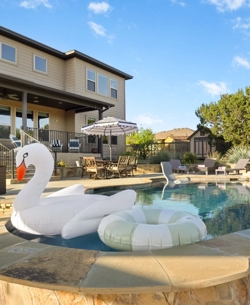 Swimming pool with a swan float and the house behind