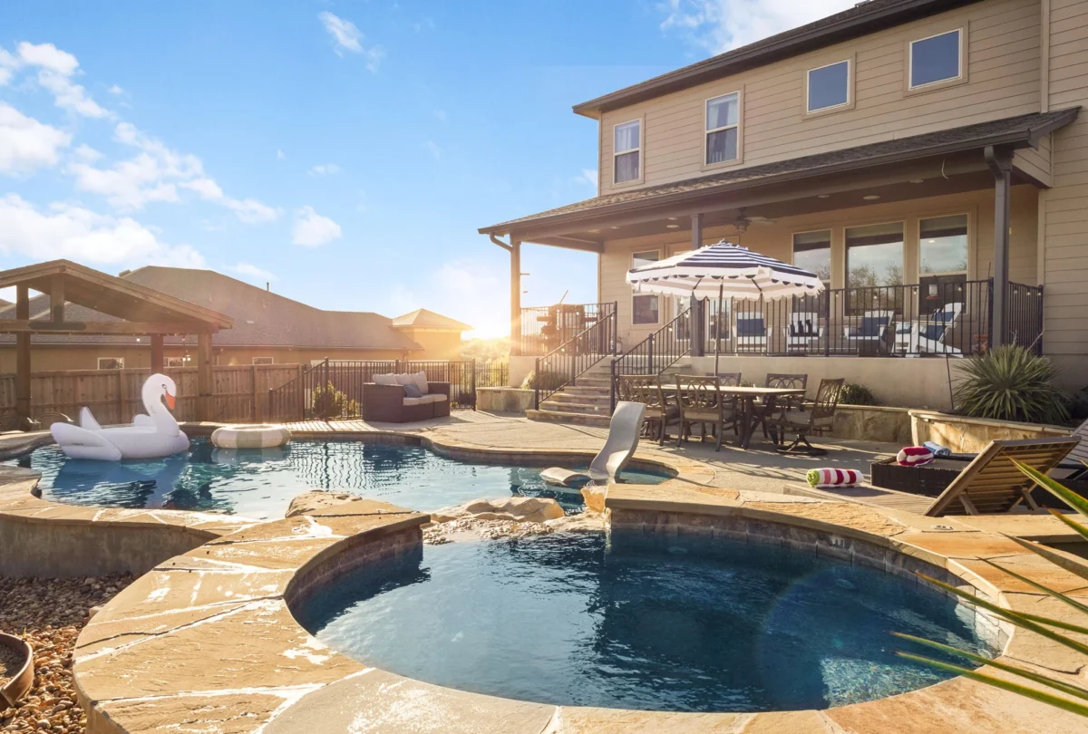 The pool at sunset with the house lit behind