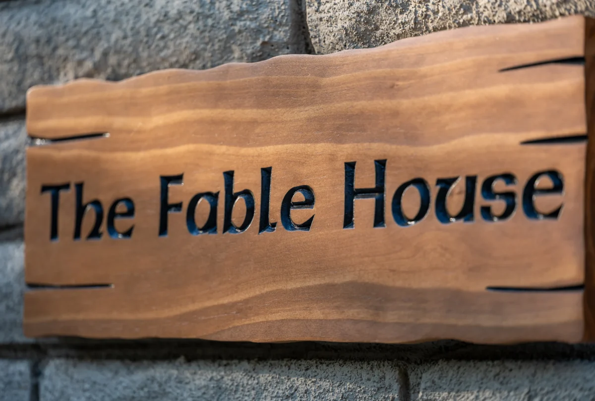 Carved wooden sign reading The Fable House