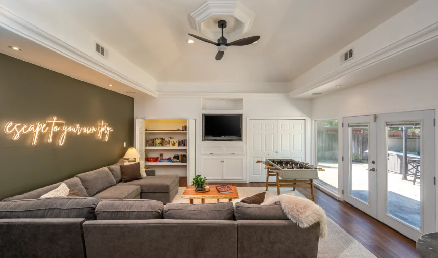 Lounge with a sectional sofa, foosball table and a neon sign reading escape to your own story