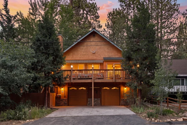 The timber cabin seen from the driveway at nightfall