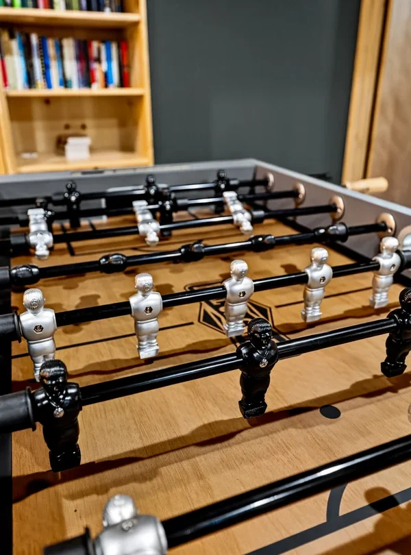 Foosball table in front of a bookshelf