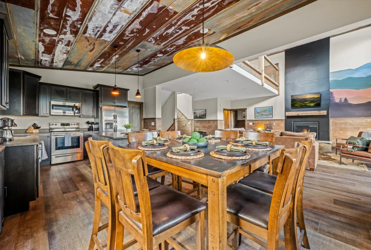 Dining table set for eight beneath a yellow pendant light
