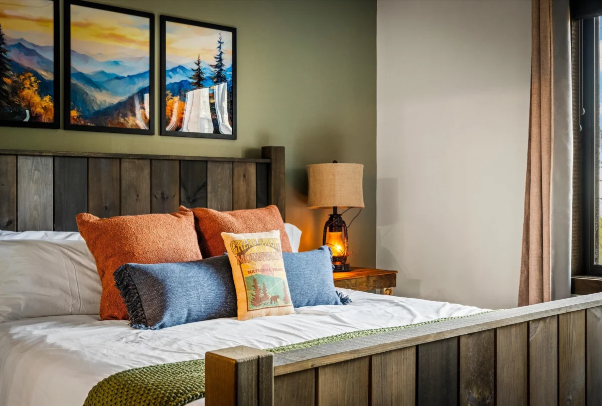 Bedroom with framed landscape prints and layered cushions